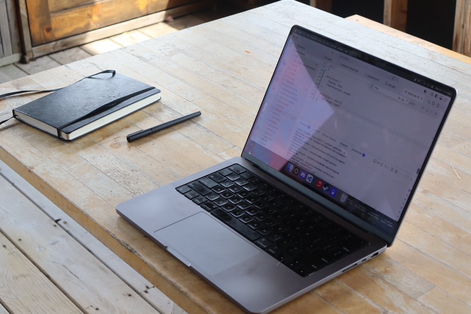 Laptop with notebook and pen on a table